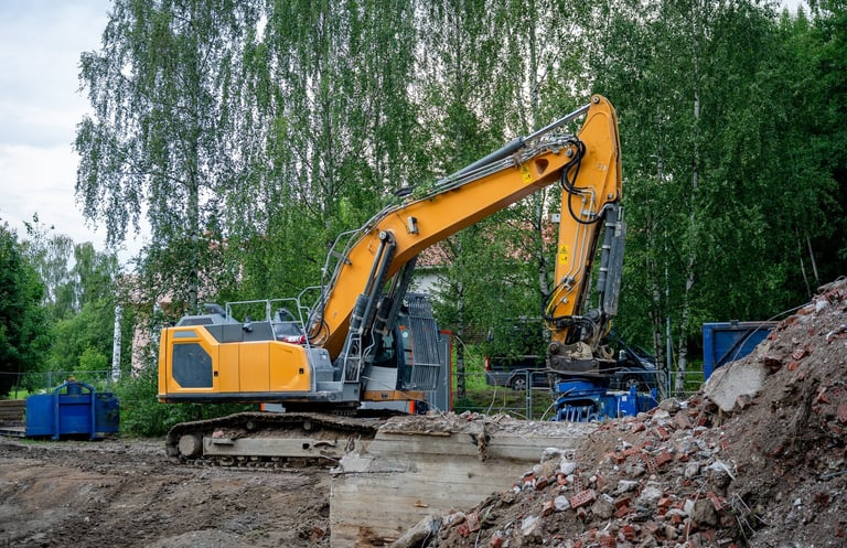 Yellow excavator demolishing concrete